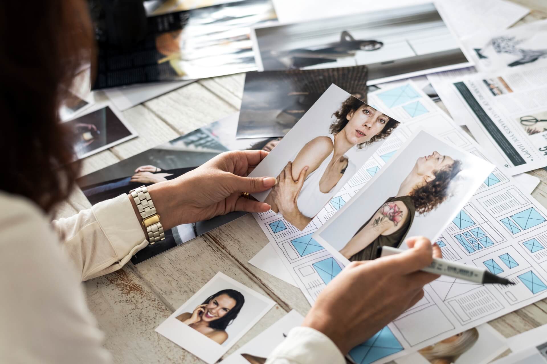 Reviewing freshly printed photographs and layouts on a work table